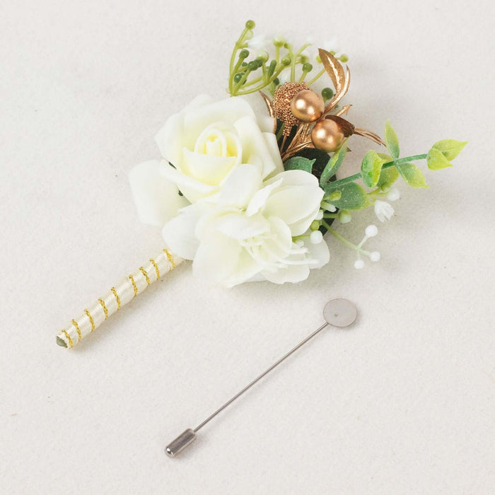 White floral boutonniere with gold accents and a pin