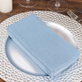 Stack of light blue napkins on a decorative silver plate.