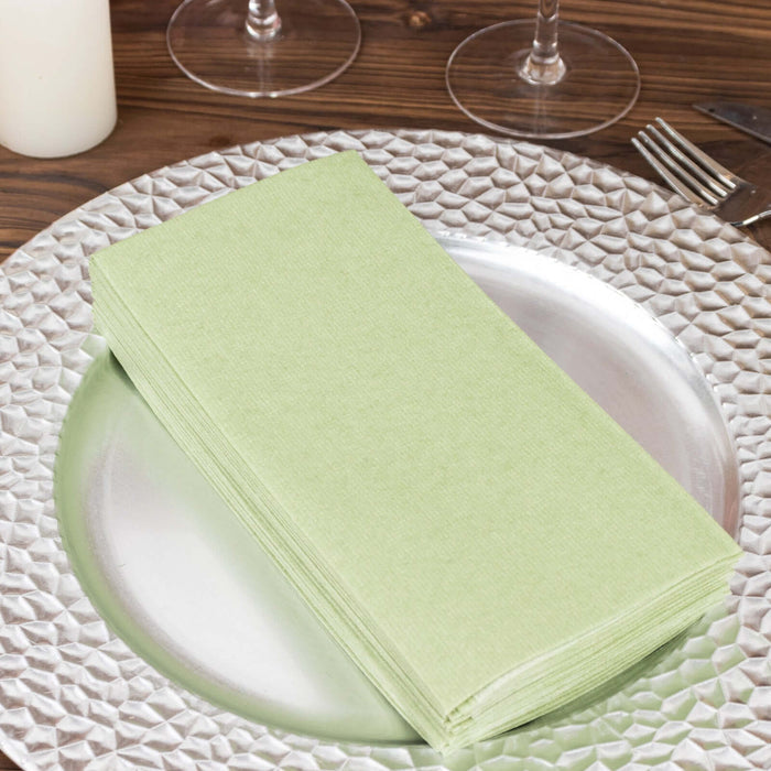 Stack of light green napkins on a decorative silver plate.