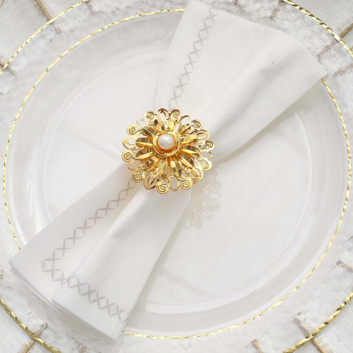 Elegant napkin ring with pearl and gold floral design on a white napkin.