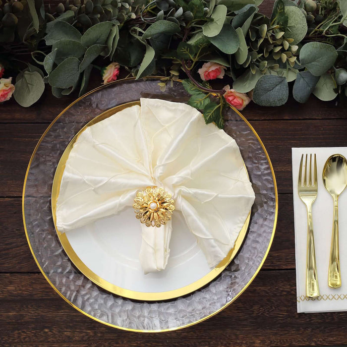 Elegant ivory napkin with gold ring on a decorative plate, set for dining.