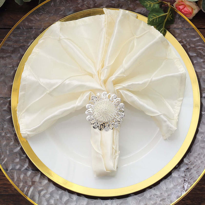 Elegant cream napkin with silver ring on a decorative plate.