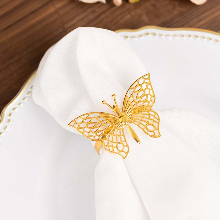 Golden butterfly napkin ring on a white napkin atop an elegant plate.