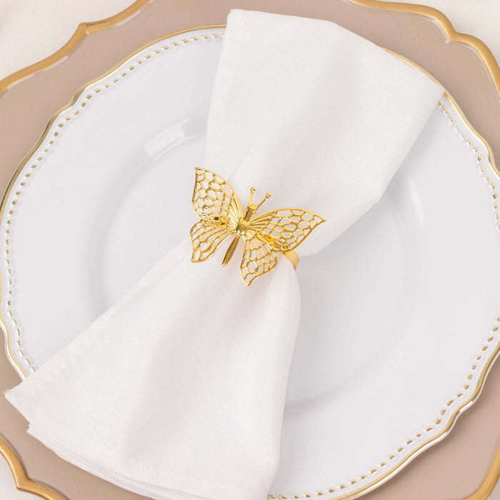 Gold butterfly napkin ring on a white plate with a folded napkin.