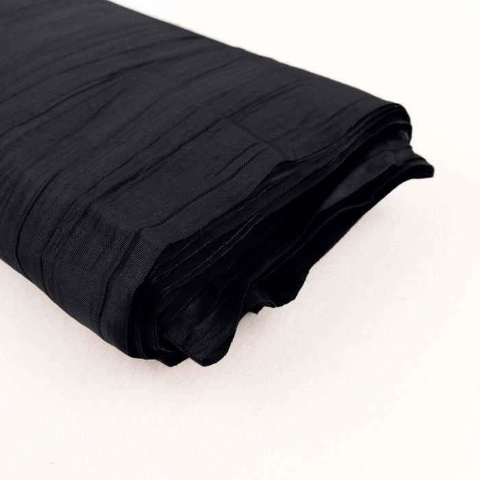 Black textured fabric roll on a plain background