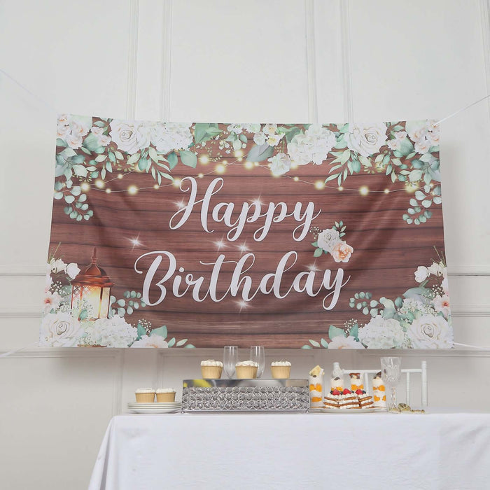 Happy Birthday banner with floral design and lantern on wooden background.