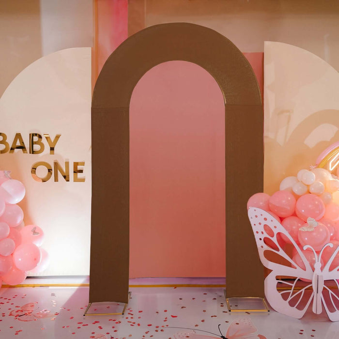 Brown decorative arch for baby event backdrop with balloons and butterfly accents.