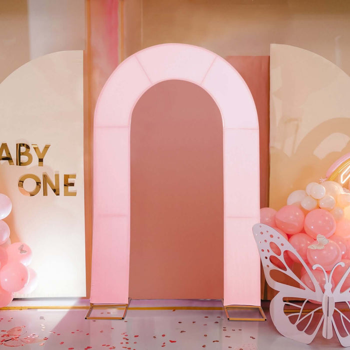 Pink arch backdrop for baby events with decorative balloons and butterfly accents.