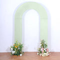 Green arch with floral arrangements on both sides, studio shot.