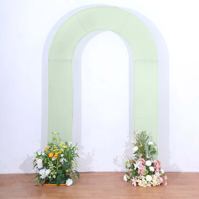 Green arch with floral arrangements on both sides, studio shot.