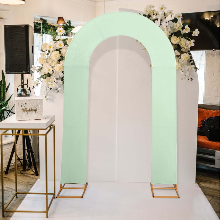 Mint green arch decoration with floral backdrop in a venue setting.