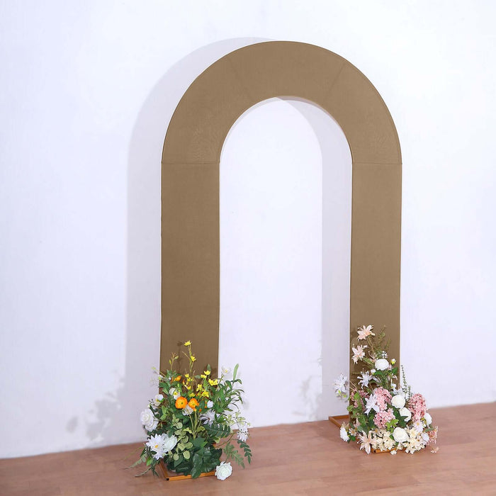 Brown arch with floral arrangements at the base in a studio setting.