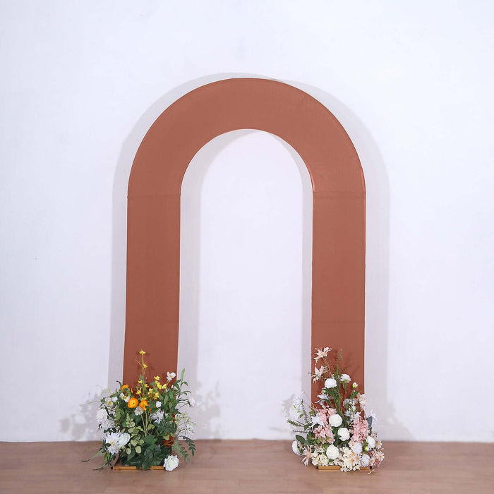 Brown arch backdrop with floral arrangements on either side.