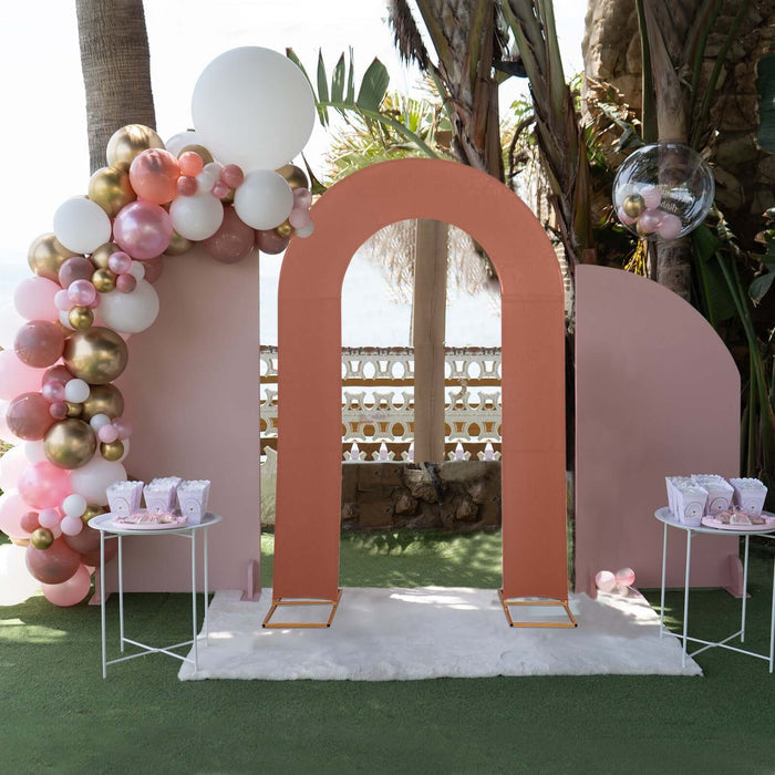 Event photo booth with pink and gold balloons and an arch backdrop.
