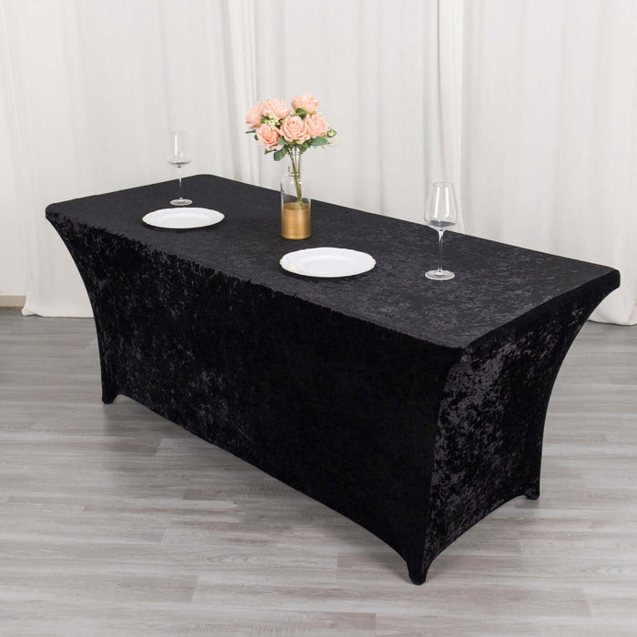 Black table cover with plates and glasses set for an elegant dining setup.