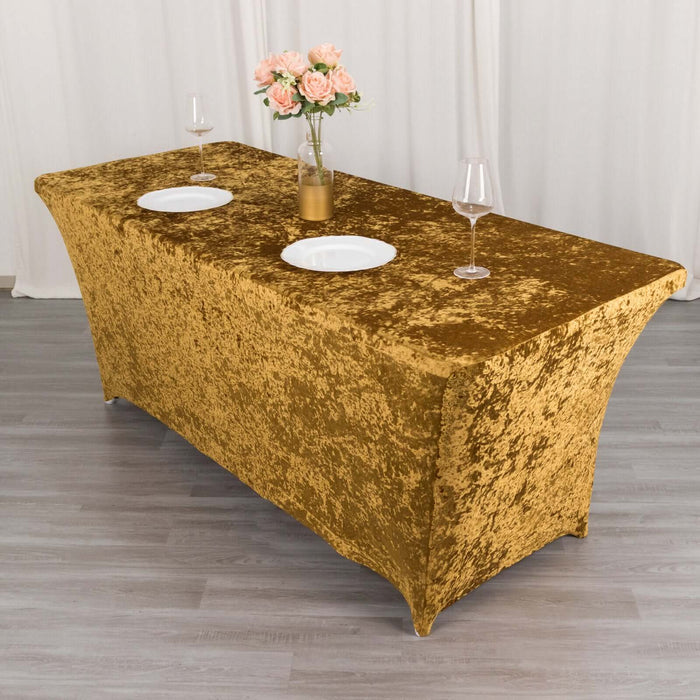 Gold velvet table cover with two plates and wine glasses on a styled table.