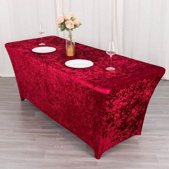 Red velvet tablecloth draped over a table set with plates and glasses.