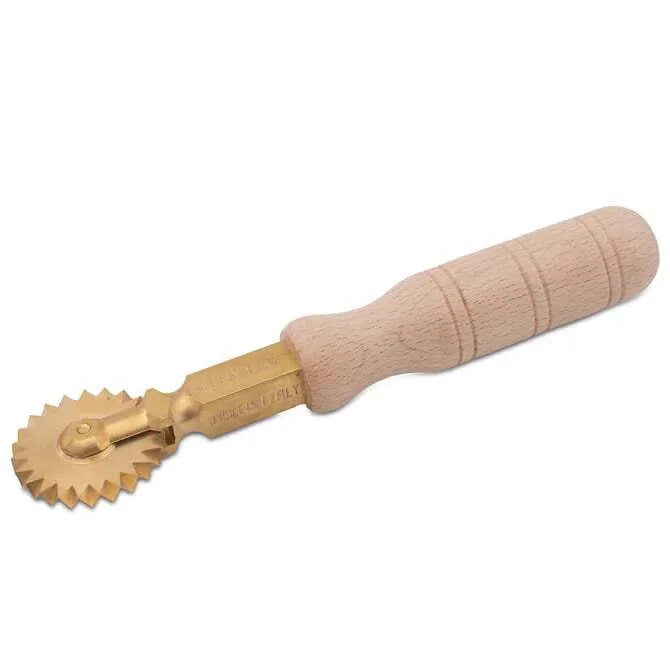 A professional brass pasta wheel with a fluted design, featuring a brass blade and a natural wood handle.