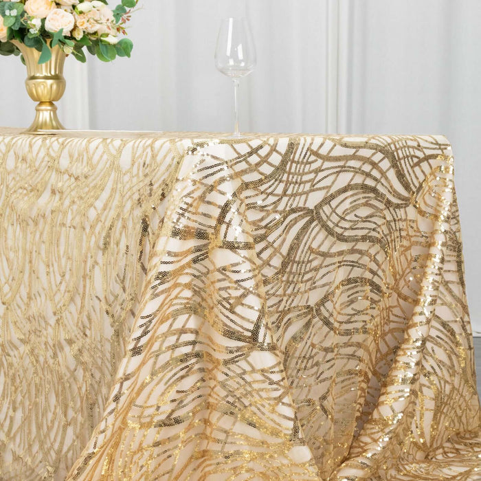 Gold sequin tablecloth draped elegantly over a table with floral centerpiece and glass.