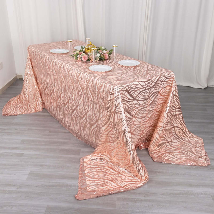 Rose gold sequin tablecloth on a dining table with floral centerpiece and plates.