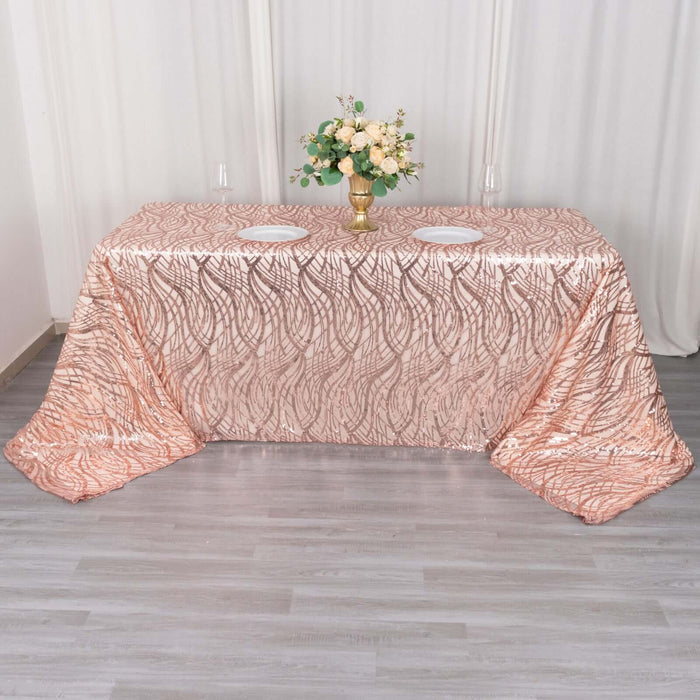 Rose gold tablecloth with wavy design on a banquet table.