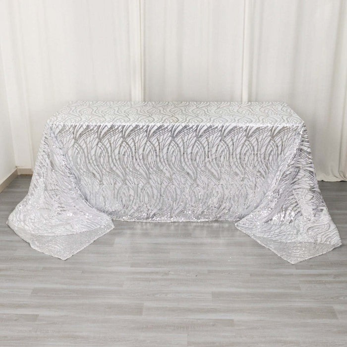 Silver sequin tablecloth with elegant leaf pattern on a neutral backdrop.
