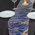 Blue and gold sequin table runner on a black table with plates and glasses.