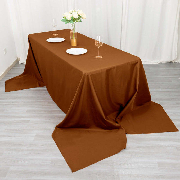 Brown tablecloth draped elegantly over a table set with plates and glasses.