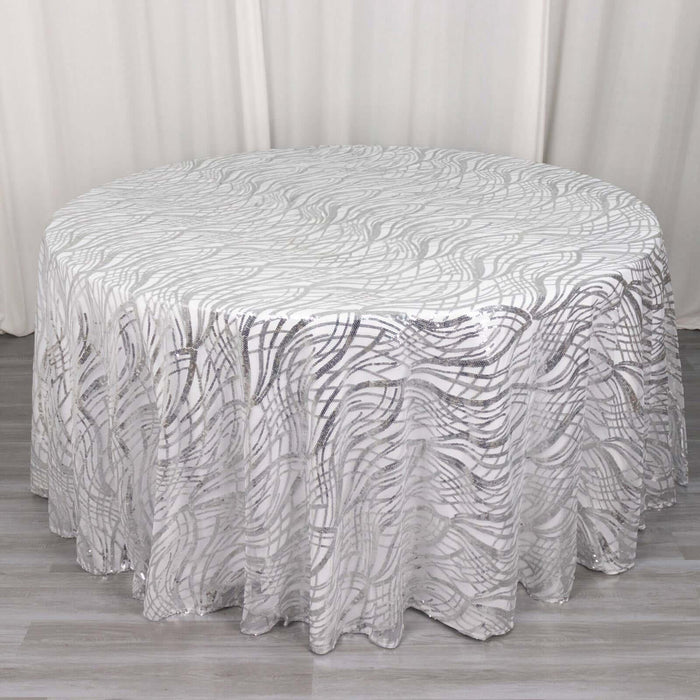 Round tablecloth with a textured silver wave pattern on a white backdrop.