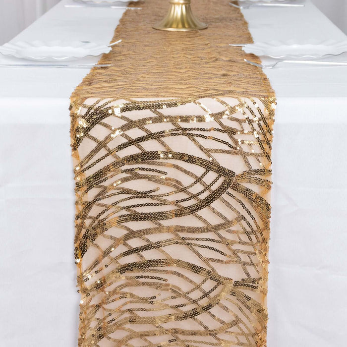 Gold sequin table runner with a wavy pattern on a white tablecloth.