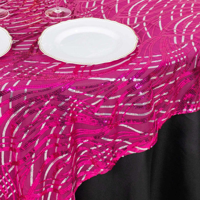 Pink sequined tablecloth with wavy patterns on a black table.
