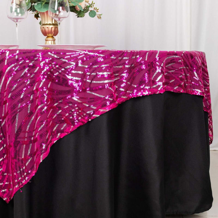 Pink sequin tablecloth draped over a black table, adding sparkle to the setting.