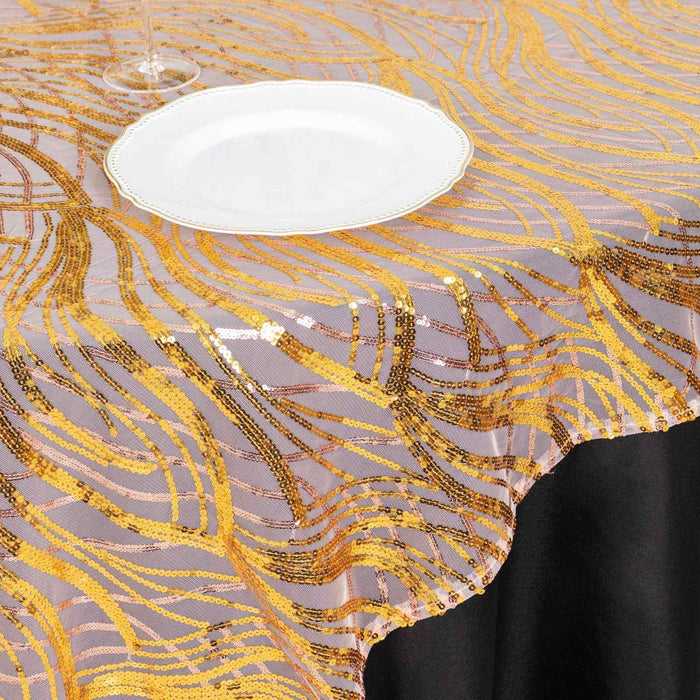 Gold and bronze sequined tablecloth with wavy pattern on a black table.