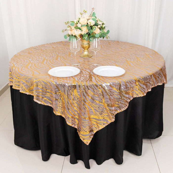 Elegant round tablecloth with golden design on black table, adorned with floral centerpiece.