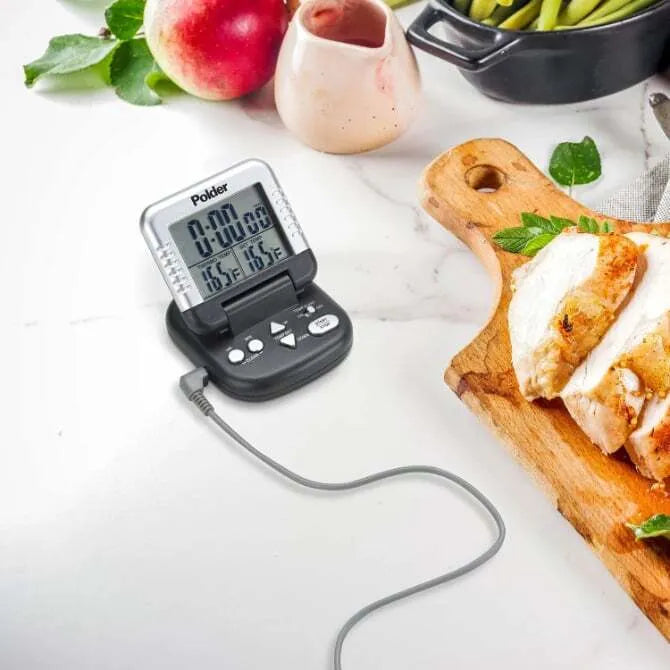 Timer/Thermometer With Probe on marble table with various foods.