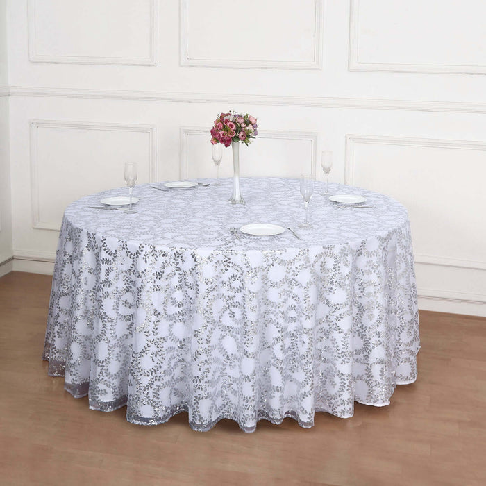 Round white lace tablecloth with elegant floral design on a wooden floor.