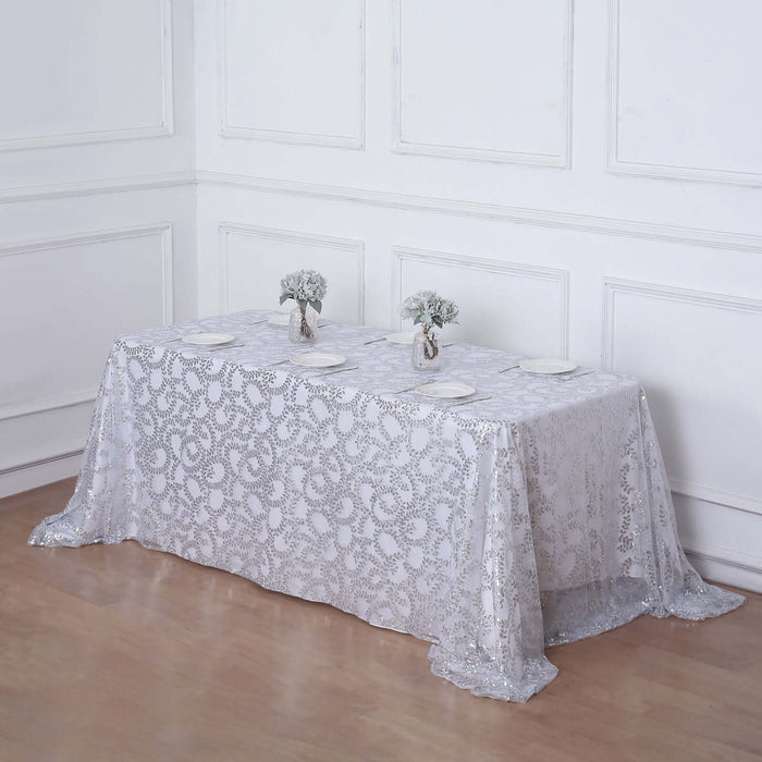 Elegant white lace tablecloth draped over a table with floral centerpieces.
